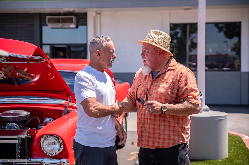 Chad Bianco talking with a resident at a local car show