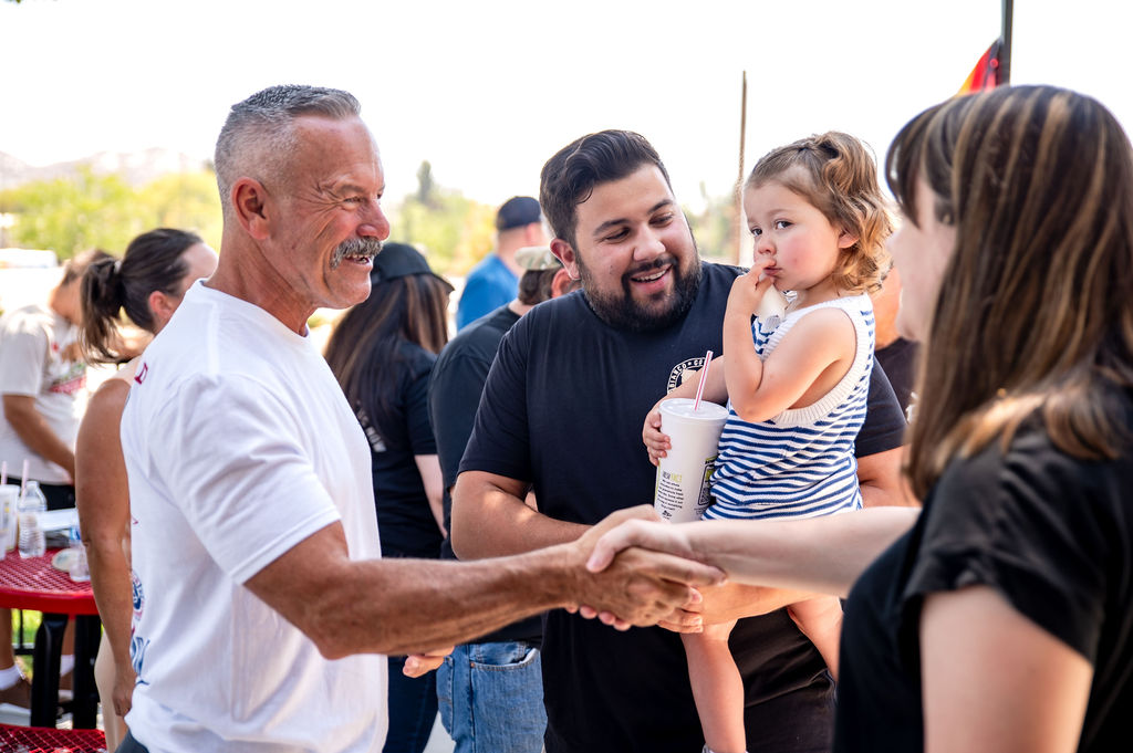 Chad Bianco greeting a family at a community event