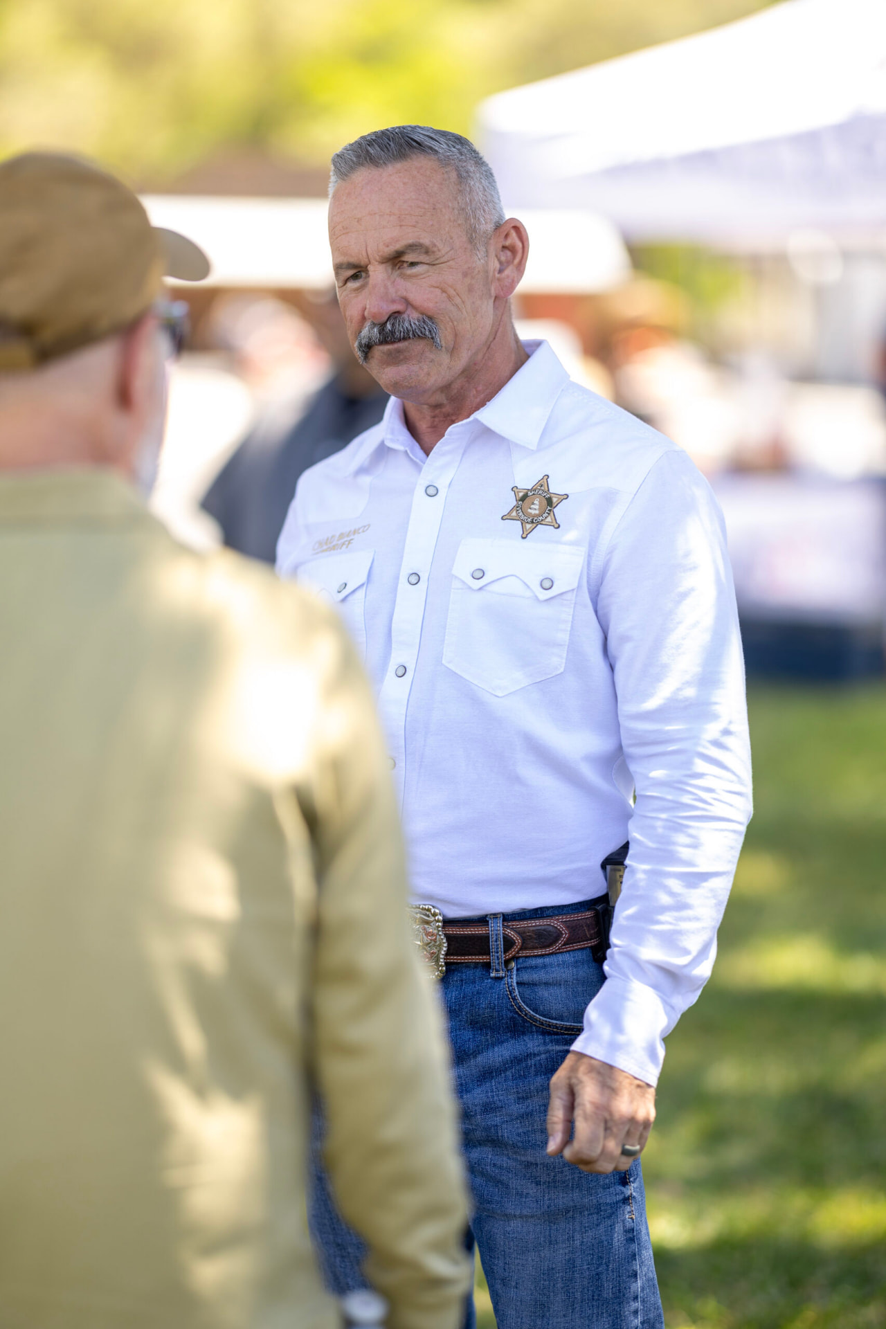 Sheriff Chad Bianco speaking with a resident at an outdoor event