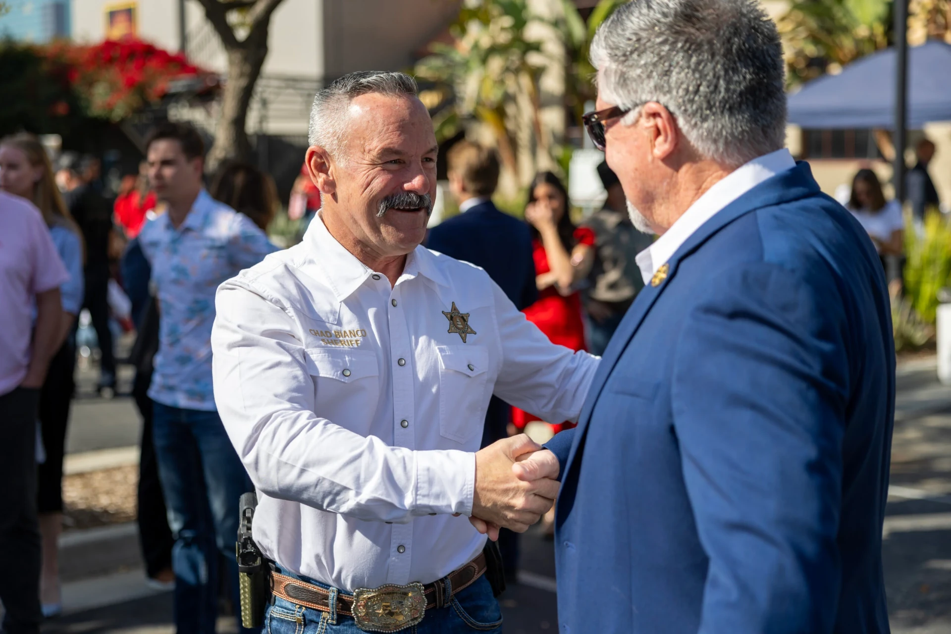 Sheriff Chad Bianco shaking hands with a supporter at a community event